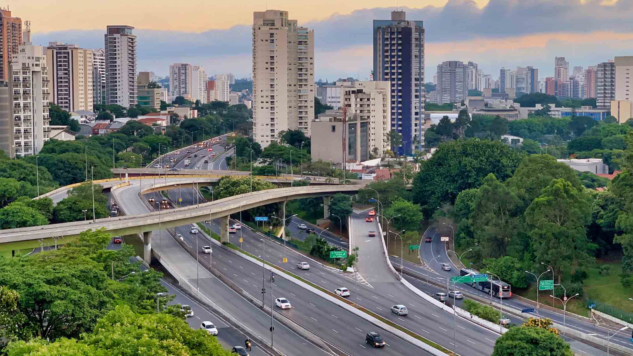 Imagem de ruas no Brasil, com veículos circulando durante o dia