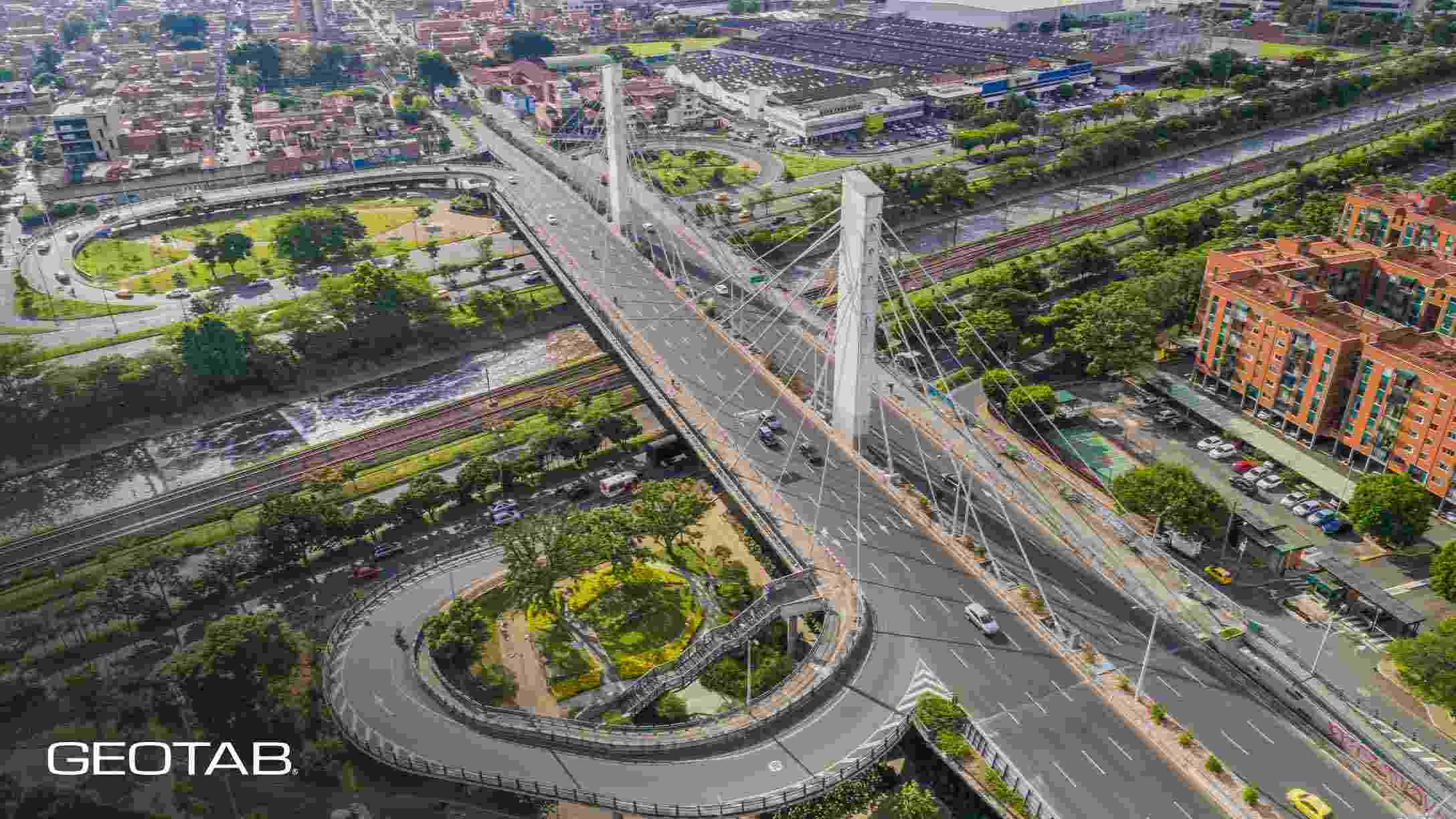 Imágen aérea de autopistas en Bogotá, de día, con vehículos circulando y áreas verdes alrededor