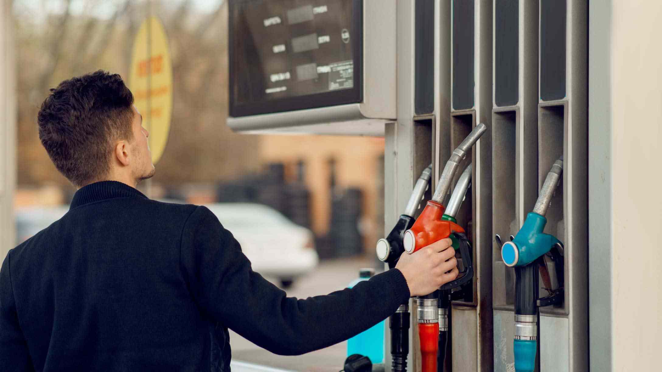 Imagen de un hombre cargando gasolina en estación