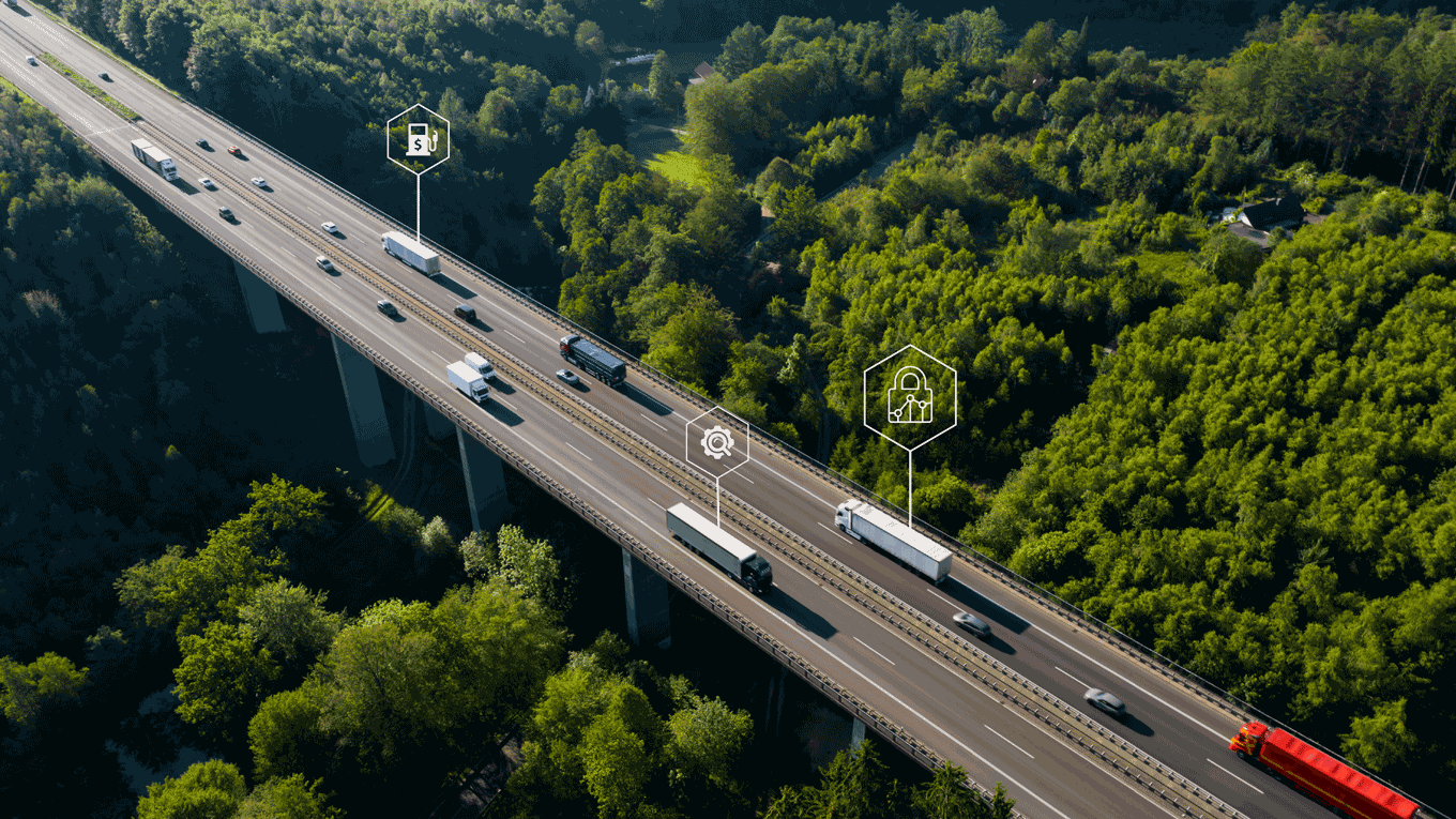 Foto aérea de varios vehículos en una carretera rodada por arboles con símbolos de data.