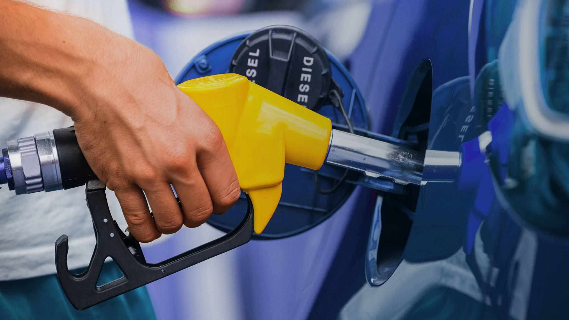 Una persona cargando gasolina en una estación de servicio de gas