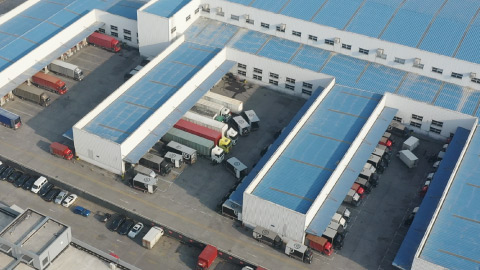 Foto de varios vehículos de carga estacionados en un almacén.