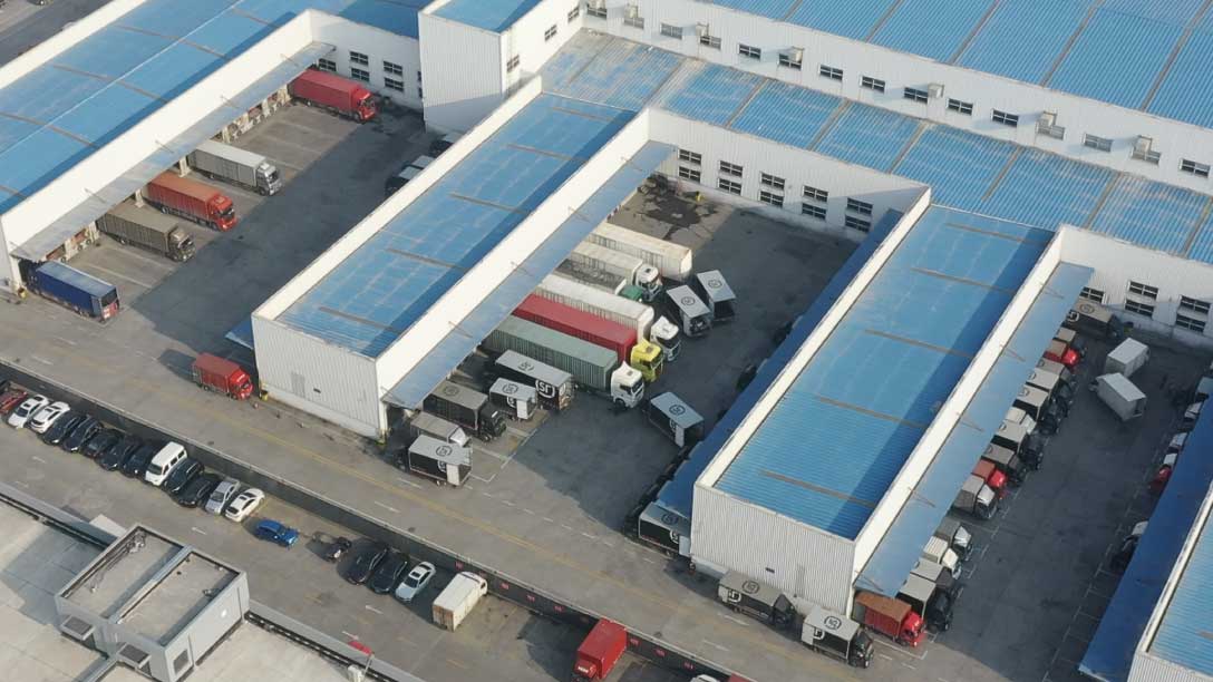 Foto de varios vehículos de carga estacionados en un almacén.