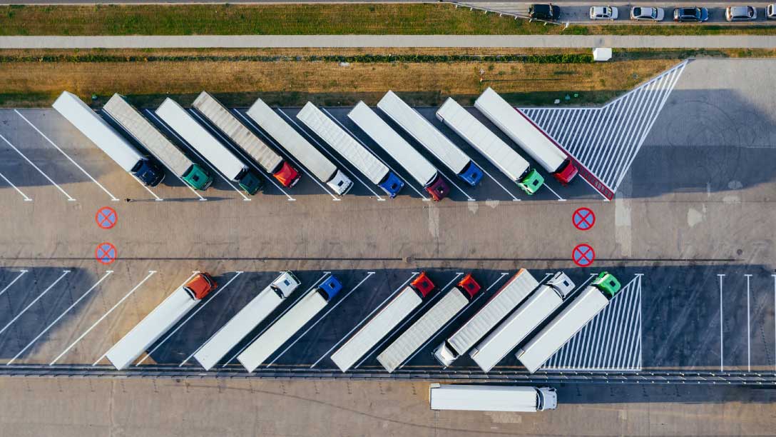 Camiones pesados estacionados en un centro logístico.