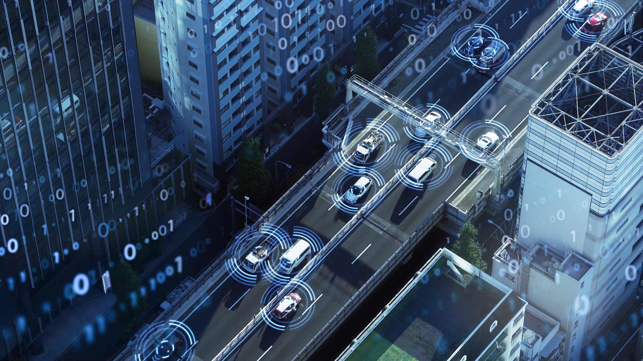 Vista aérea de vehículos autónomos conduciendo en una autopista urbana con superposiciones de datos digitales.