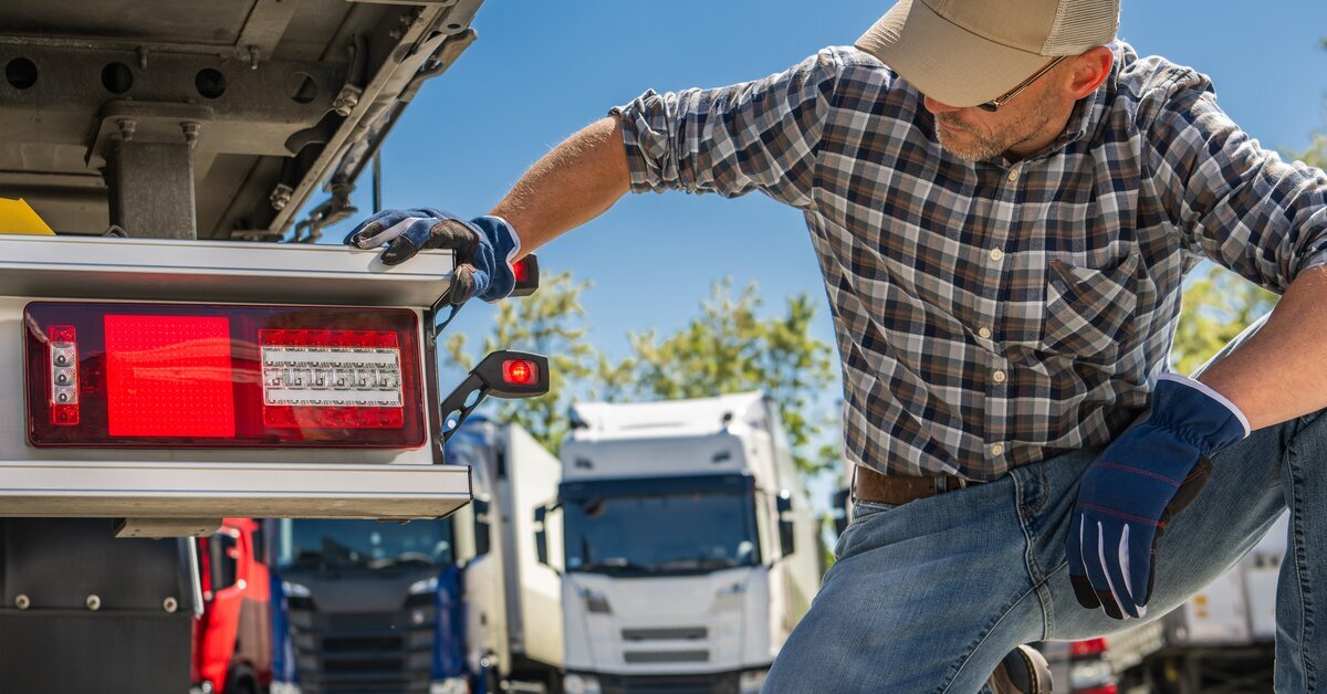 Operador realizando la inspección de luces traseras y seguridad del remolque previo a salir a ruta.