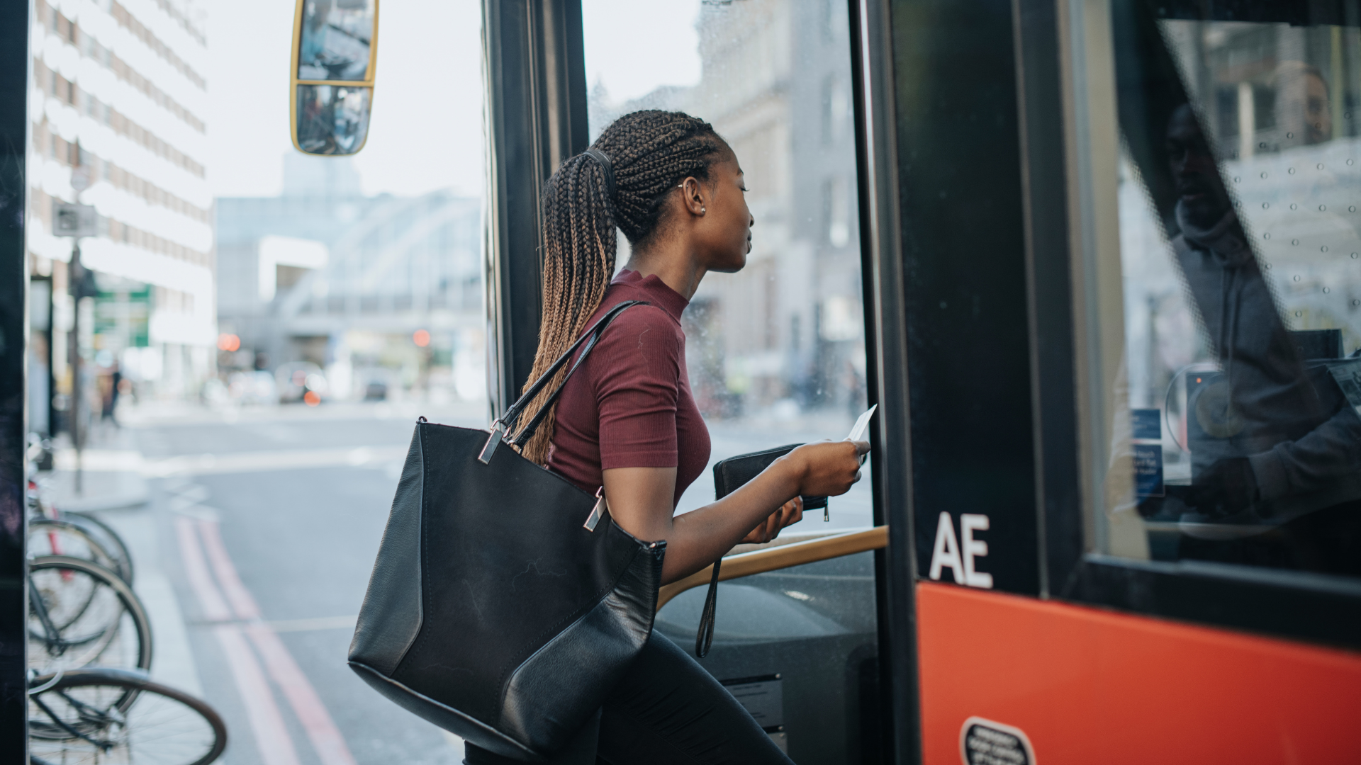 Commuter boarding a bus in an urban setting.