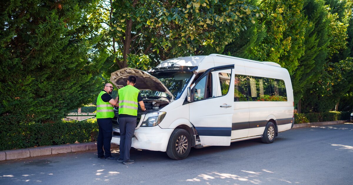 deux hommes devant un véhicule blanc