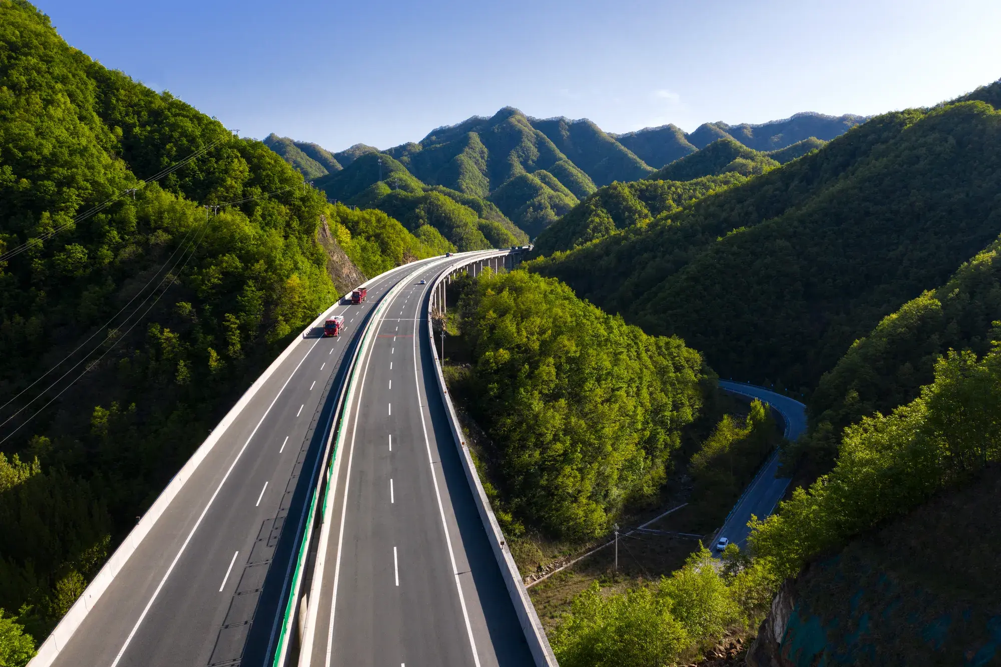 Vue aérienne d'une autoroute moderne, entourée d'arbres.