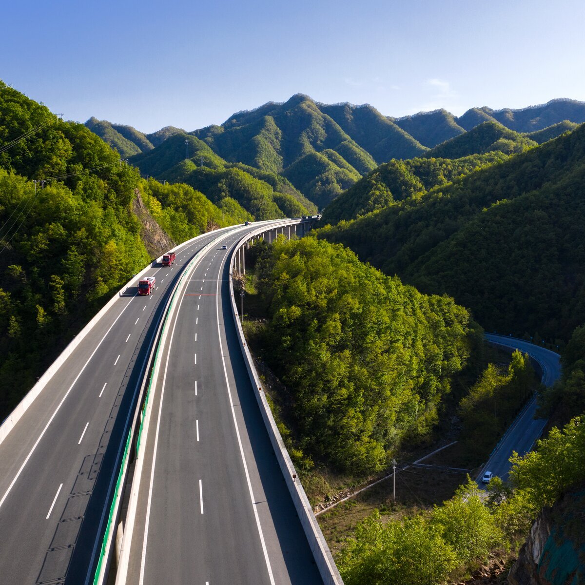 Vue aérienne d'une autoroute moderne, entourée d'arbres.