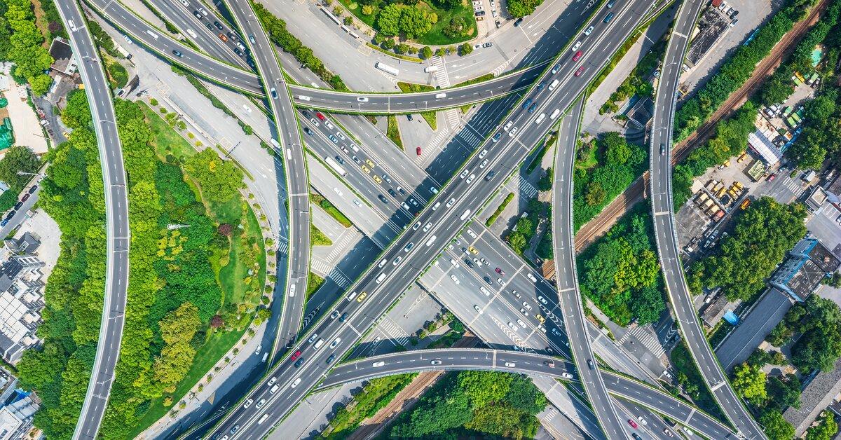 Vue aérienne d’un échangeur autoroutier très fréquenté, illustrant l’optimisation des trajets d’une flotte pour éviter les restrictions de circulation en ZFE