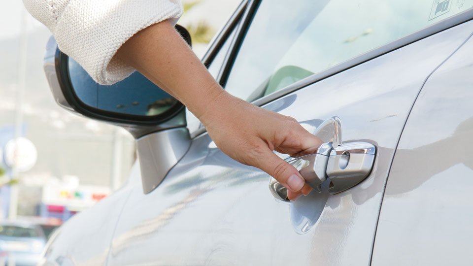 Mujer abriendo la puerta de un coche
