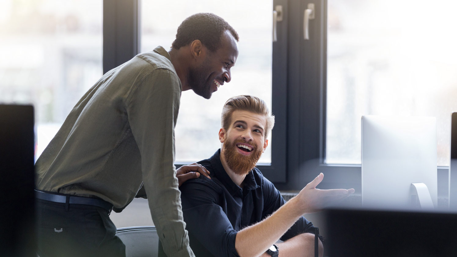 two people talking while looking at the monitor