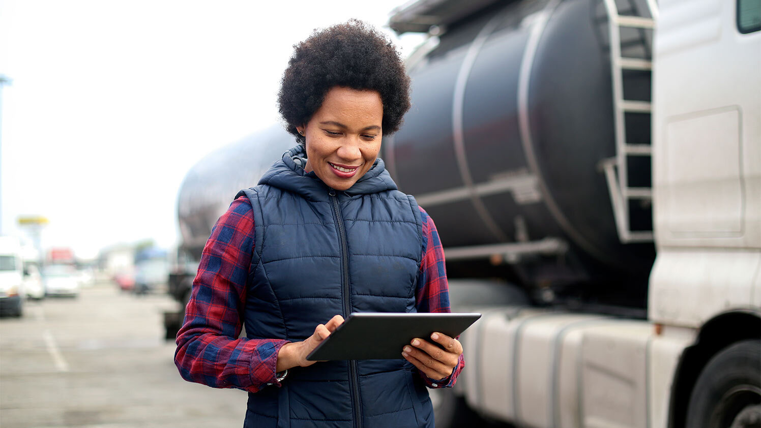 person using a tablet standing next a truck