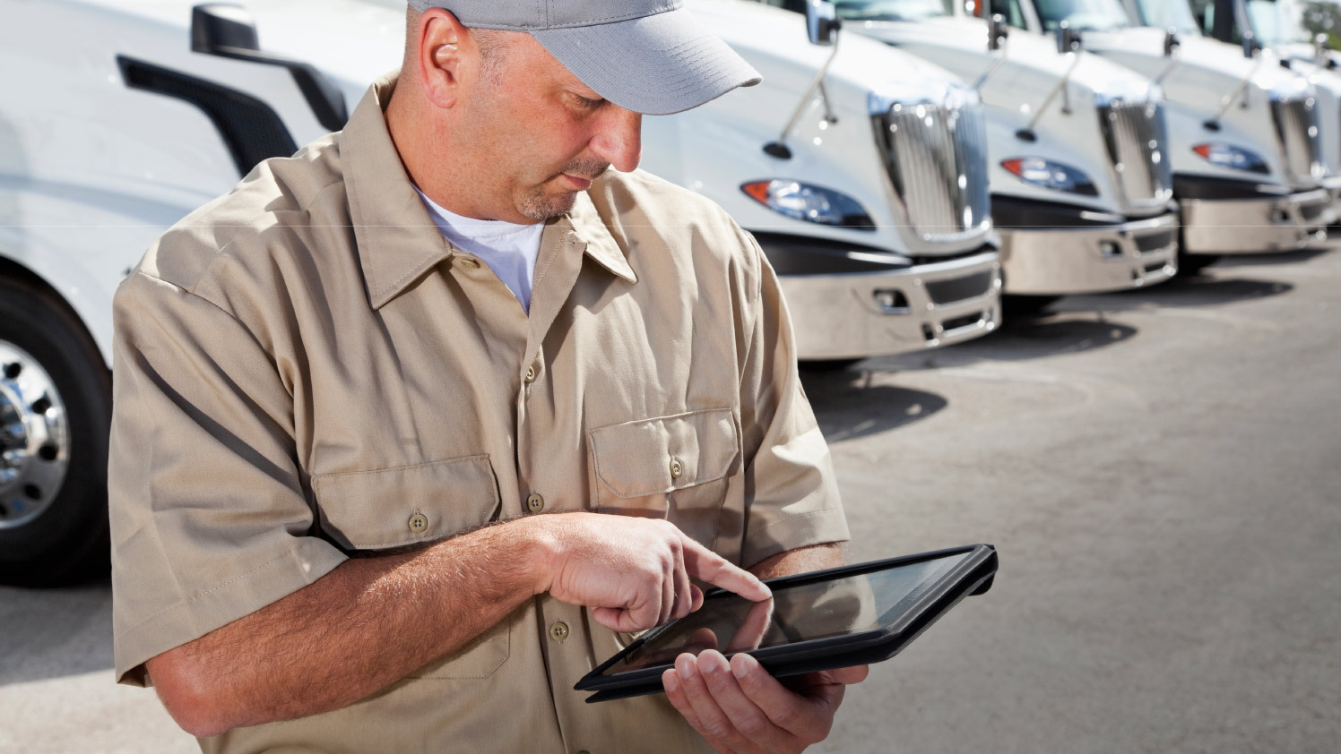 person using a tablet standing outside next to a truck