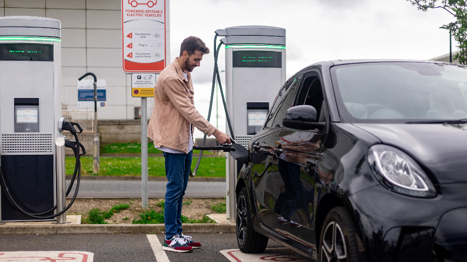 image of person plugging in electric car to charge