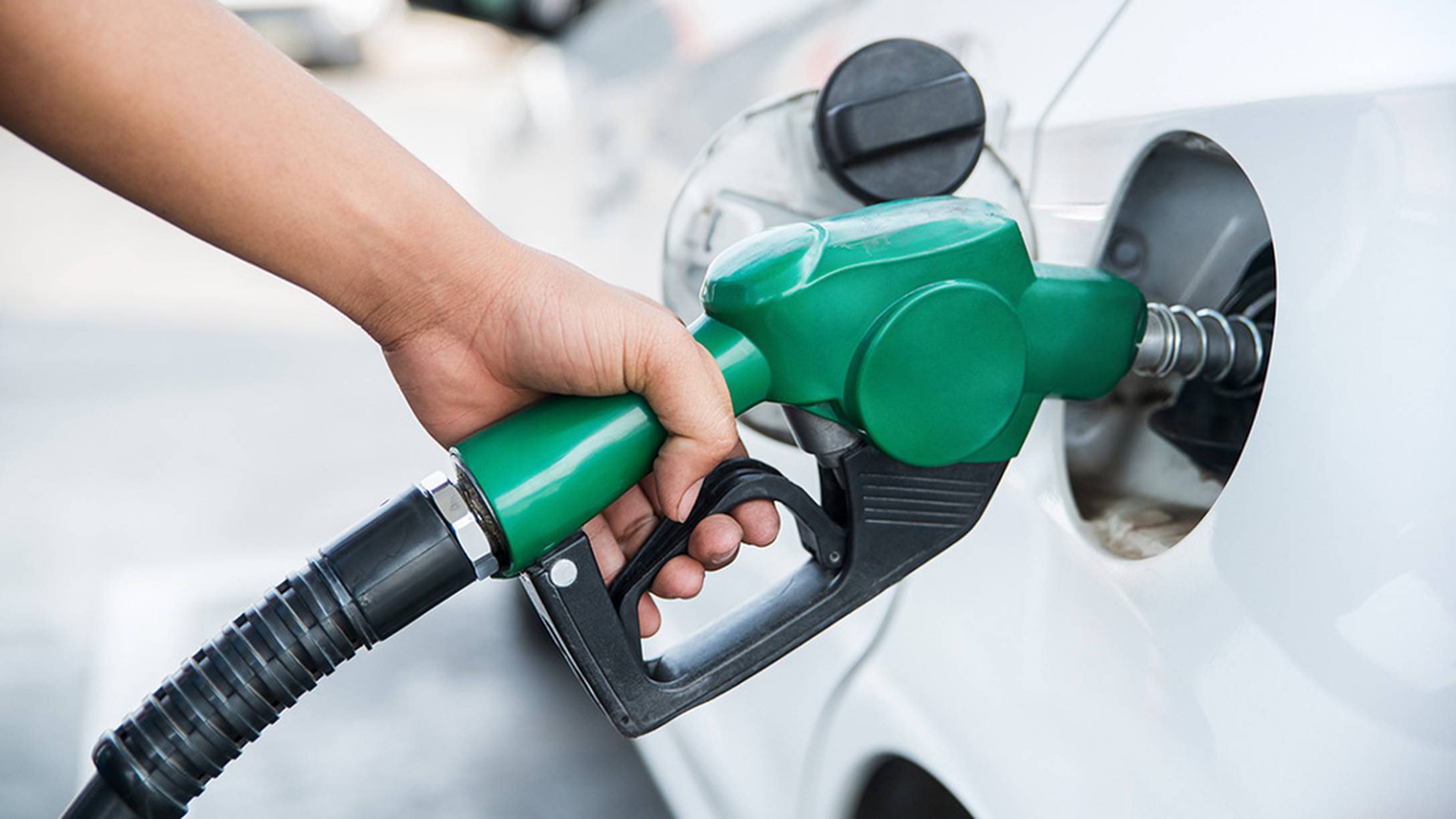 mano di una persona che tiene la pompa di benzina per fare rifornimento al veicolo