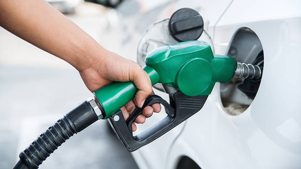 mano di una persona che tiene la pompa di benzina per fare rifornimento al veicolo