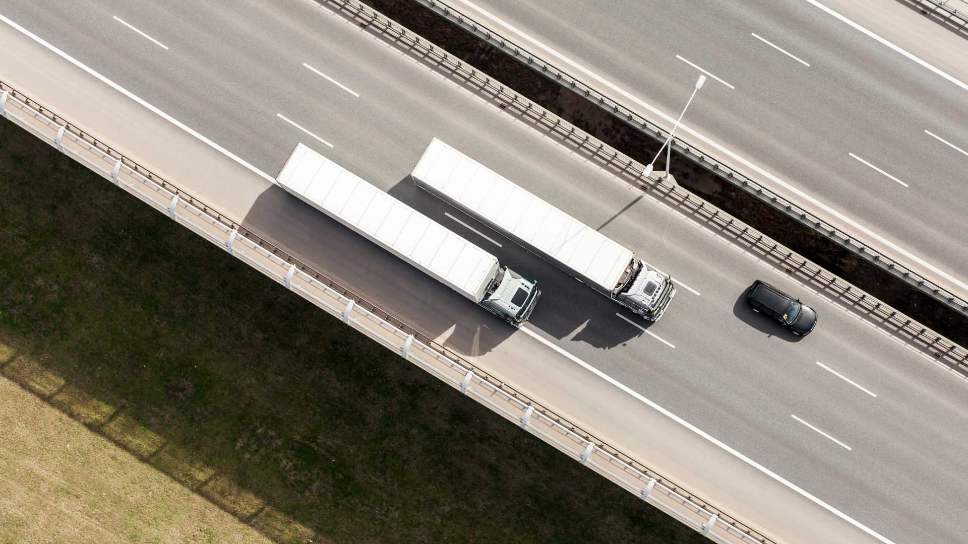 Due camion percorrono la strada.