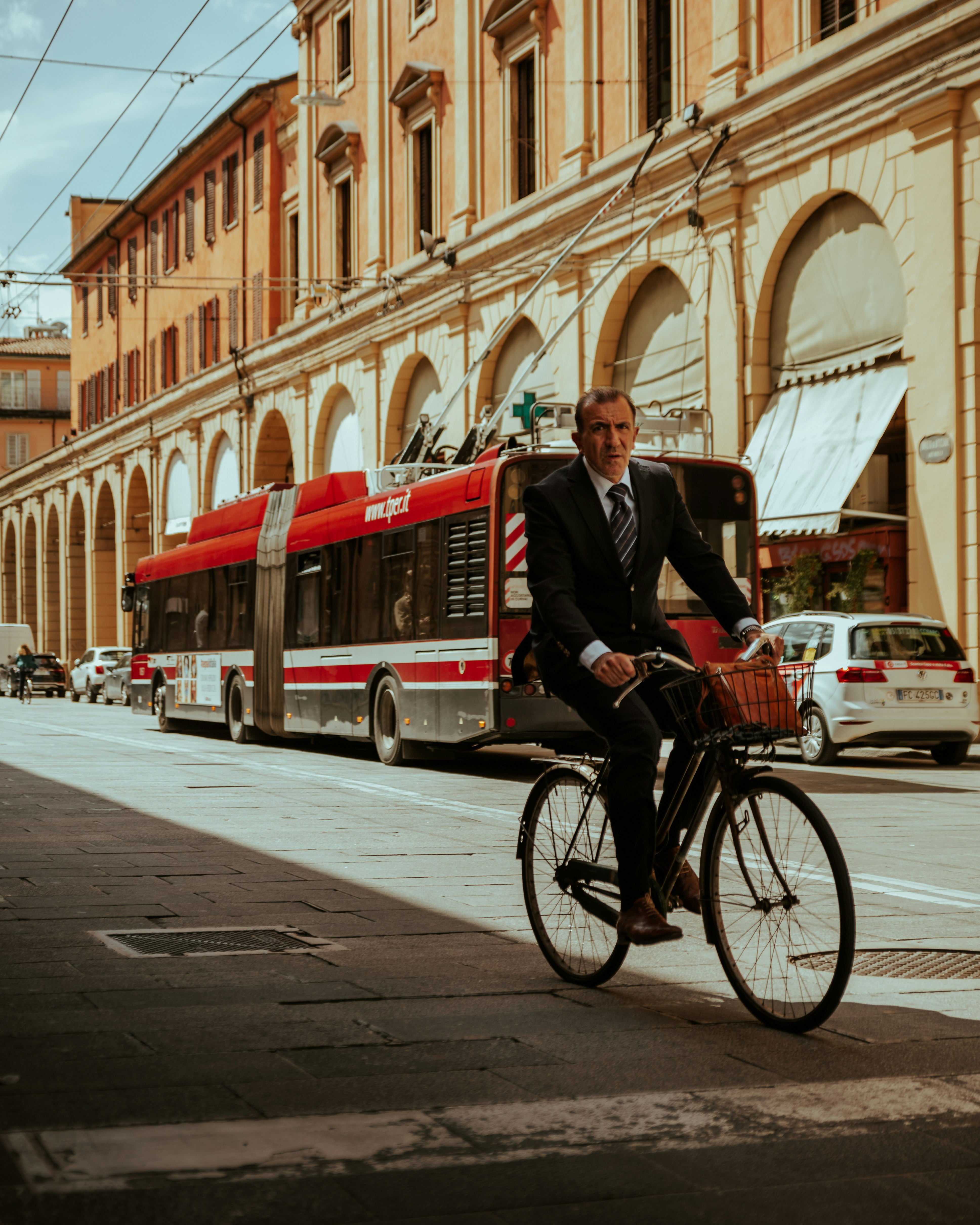 Ciclista in giacca e cravatta a passeggio a Bologna