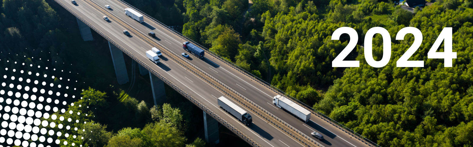 Autostrada fotografata dall'alto con veicoli in movimento. Attorno, boschi