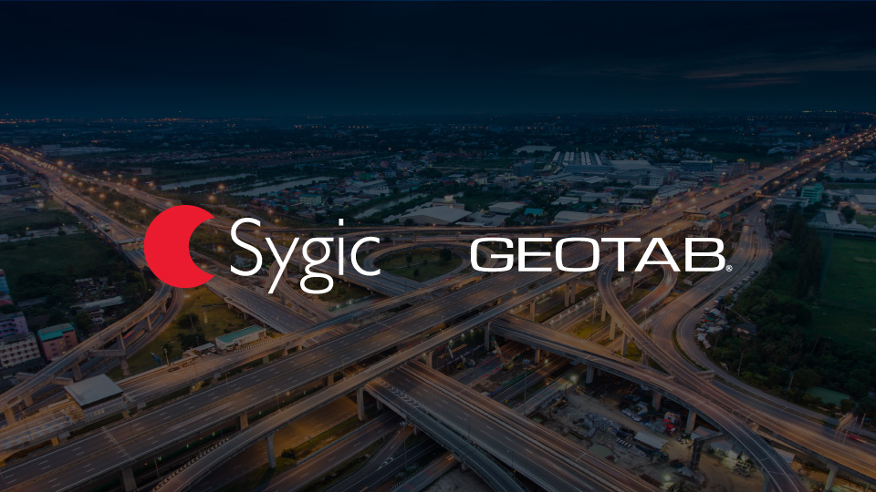 Logo Sygic e Geotab con sfondo città e strade di notte