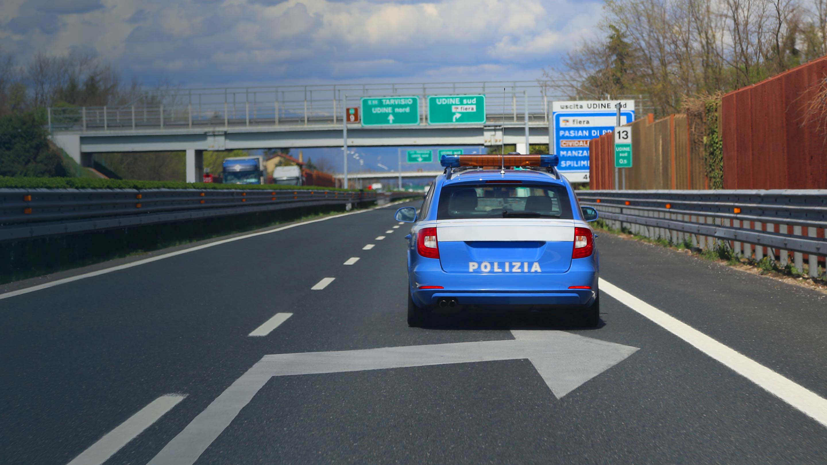 Foto di una macchina della polizia vista da dietro che guida sull'autostrada