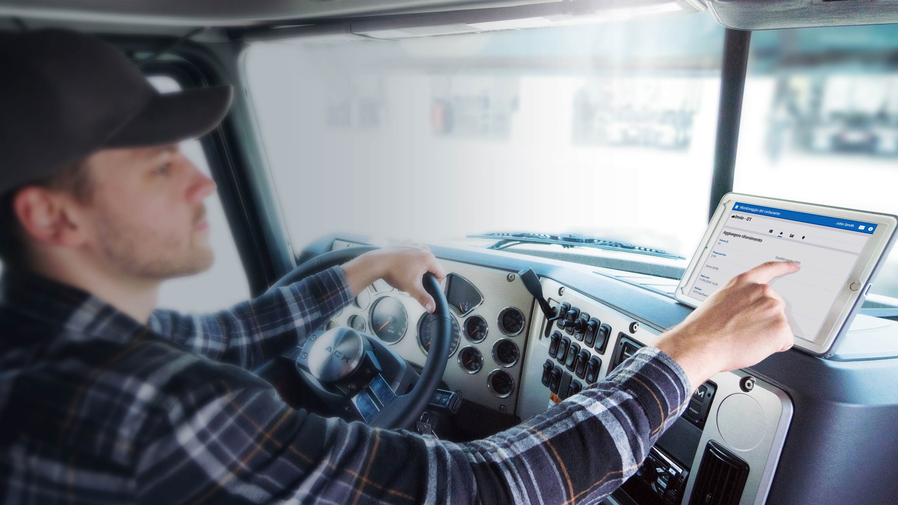 Una persona che guida un camion con un tablet che mostra Geotab Drive sul cruscotto