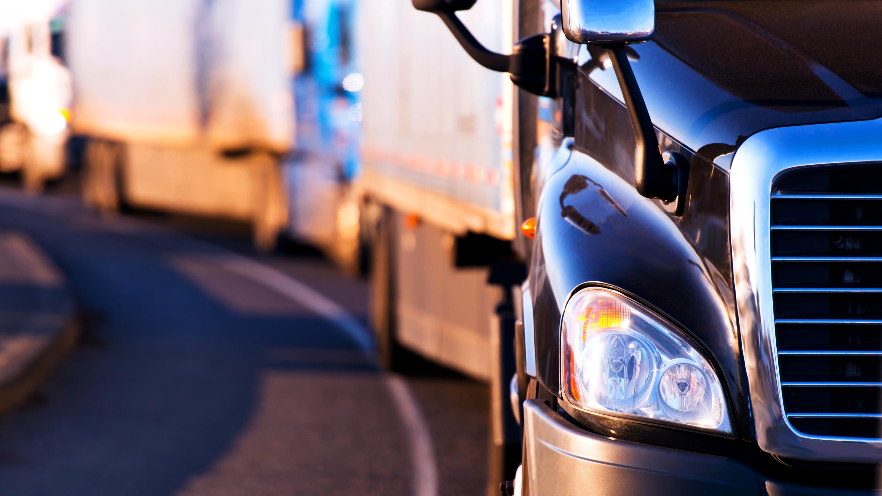 Front view of line of trucks driving on road