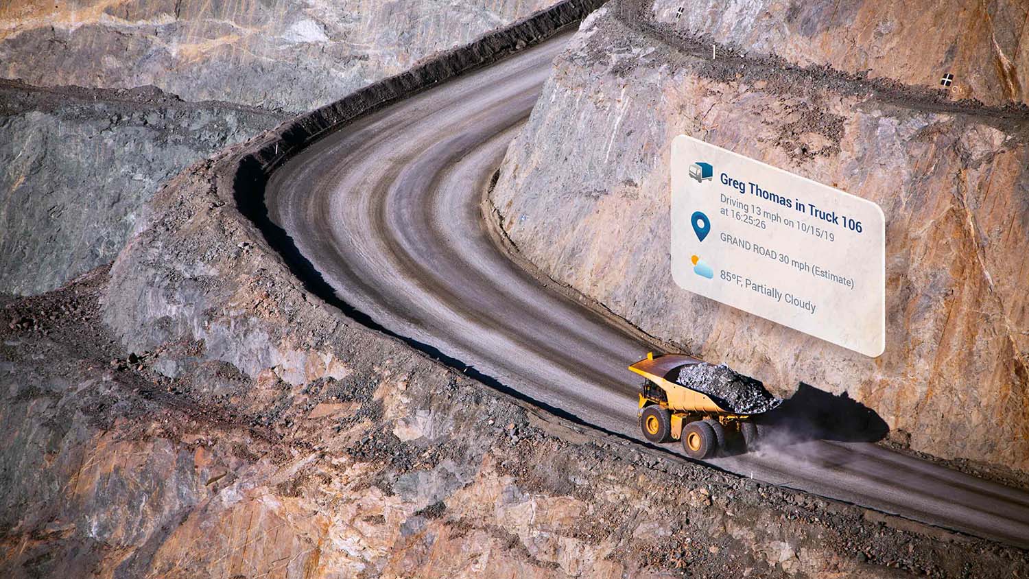 Construction truck driving on a road providing information such as speed, location, and weather through the Go Device. 