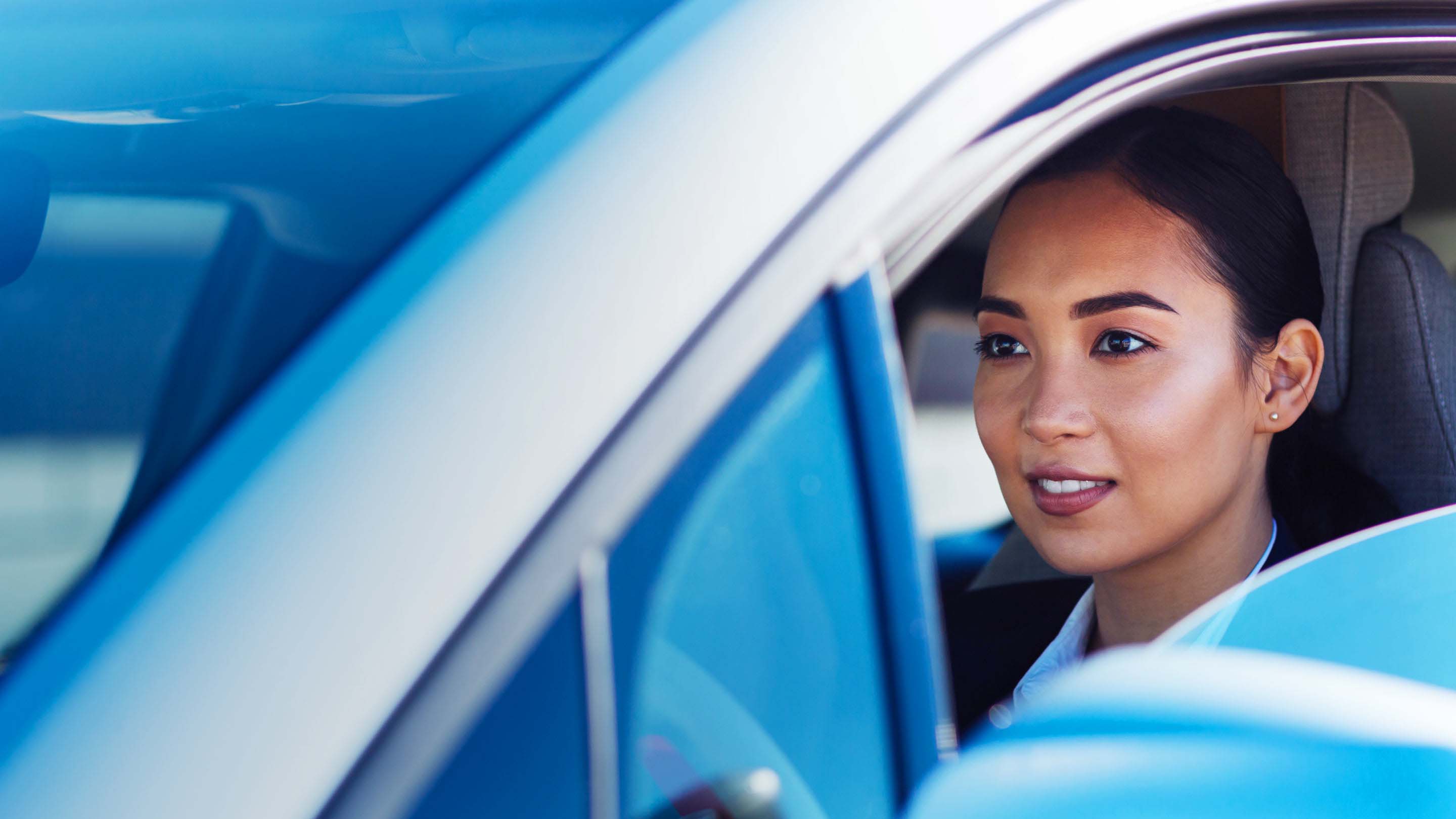 Woman smiling and driving vehicle