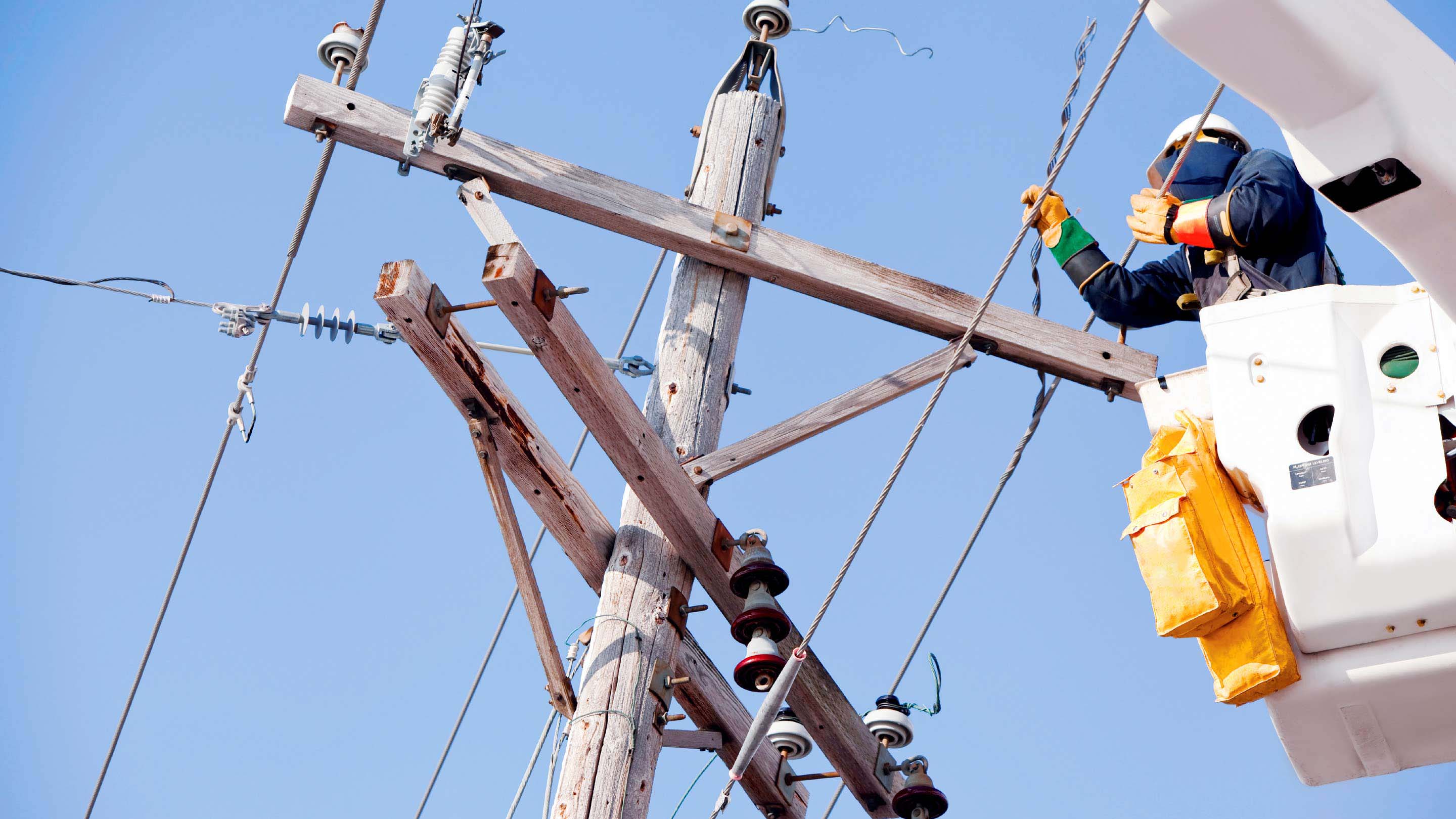 Persona trabajando en una estructura de energía eléctrica