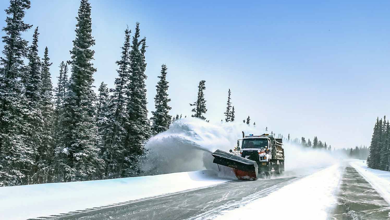 Orange snow plow truck collecting snow