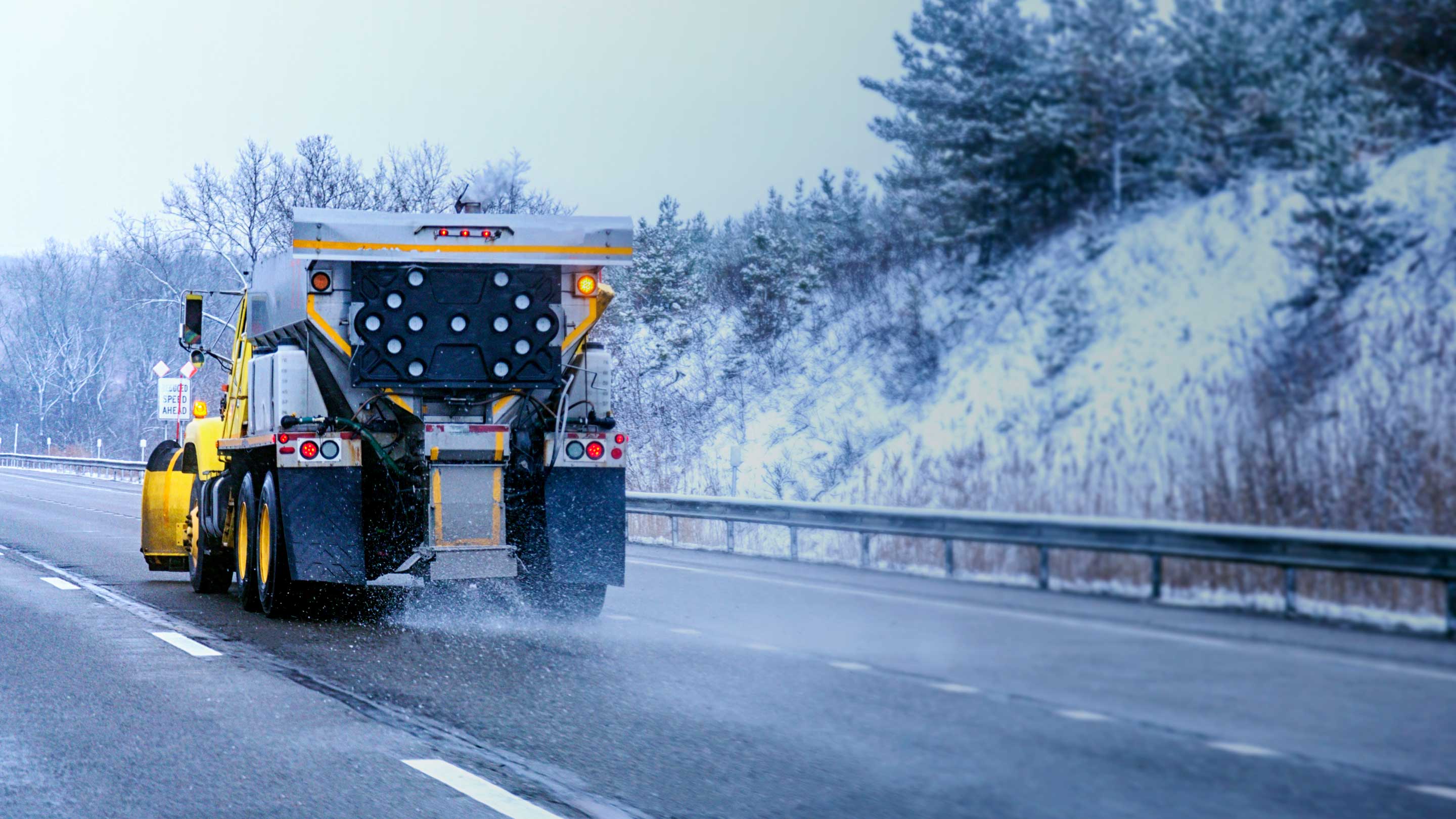 Un camion jaune roulant en hiver.