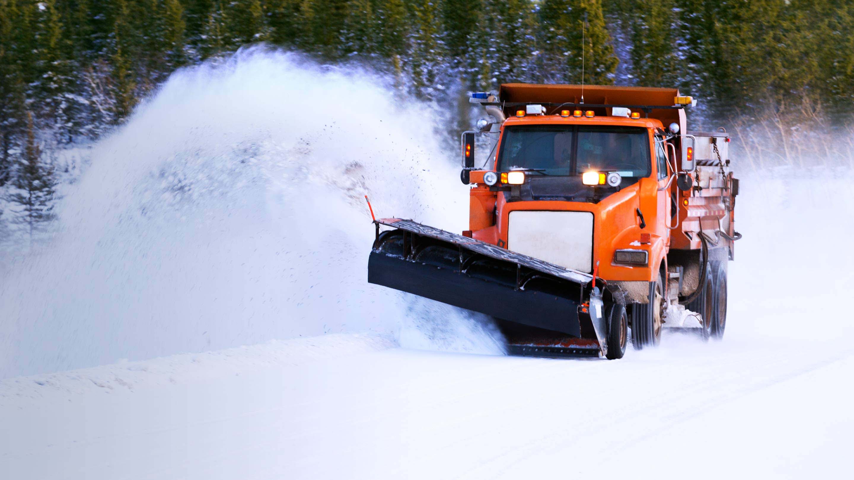 Un camion orange roulant en hiver