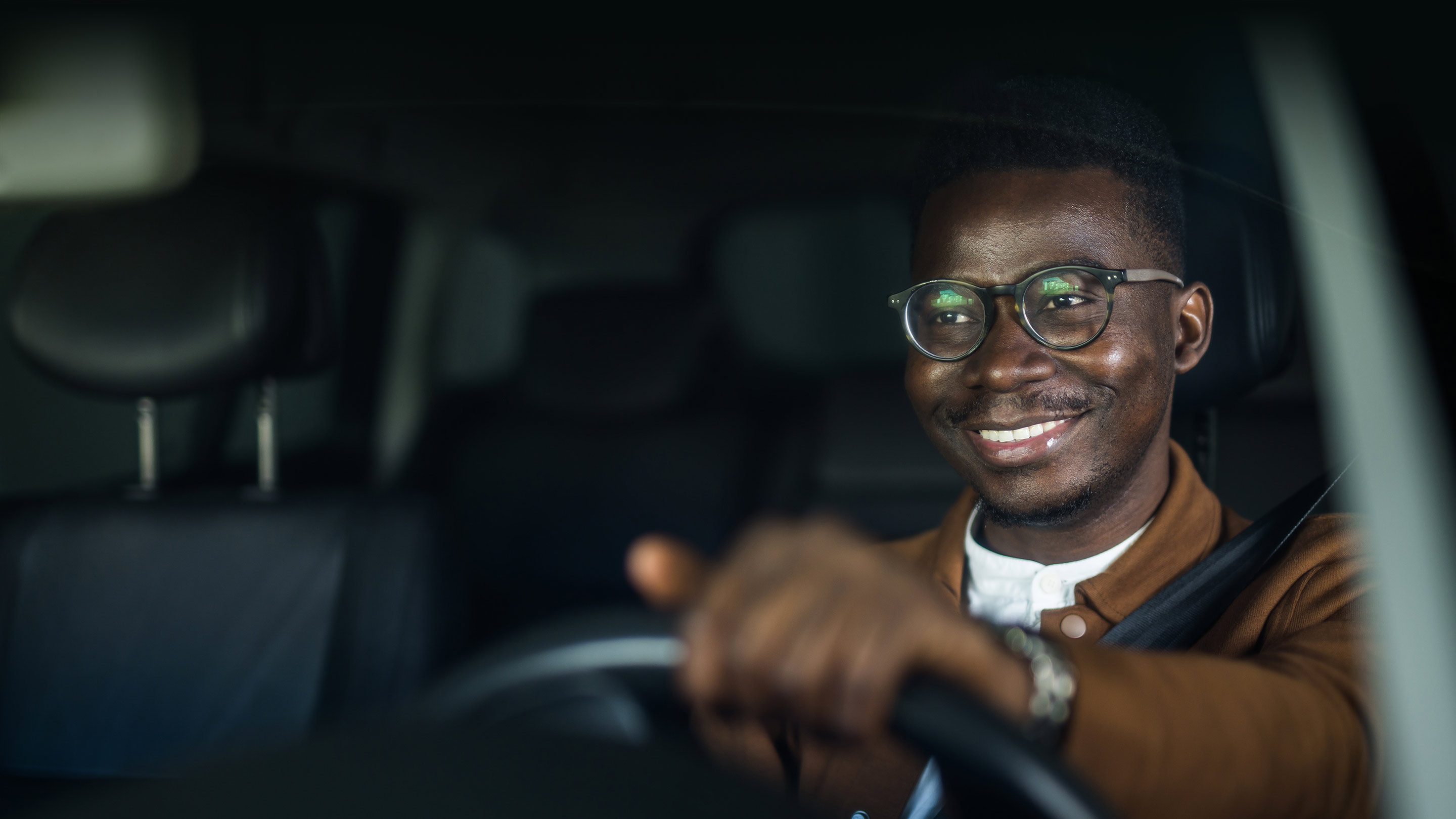 man driving a vehicle behind the steering wheel