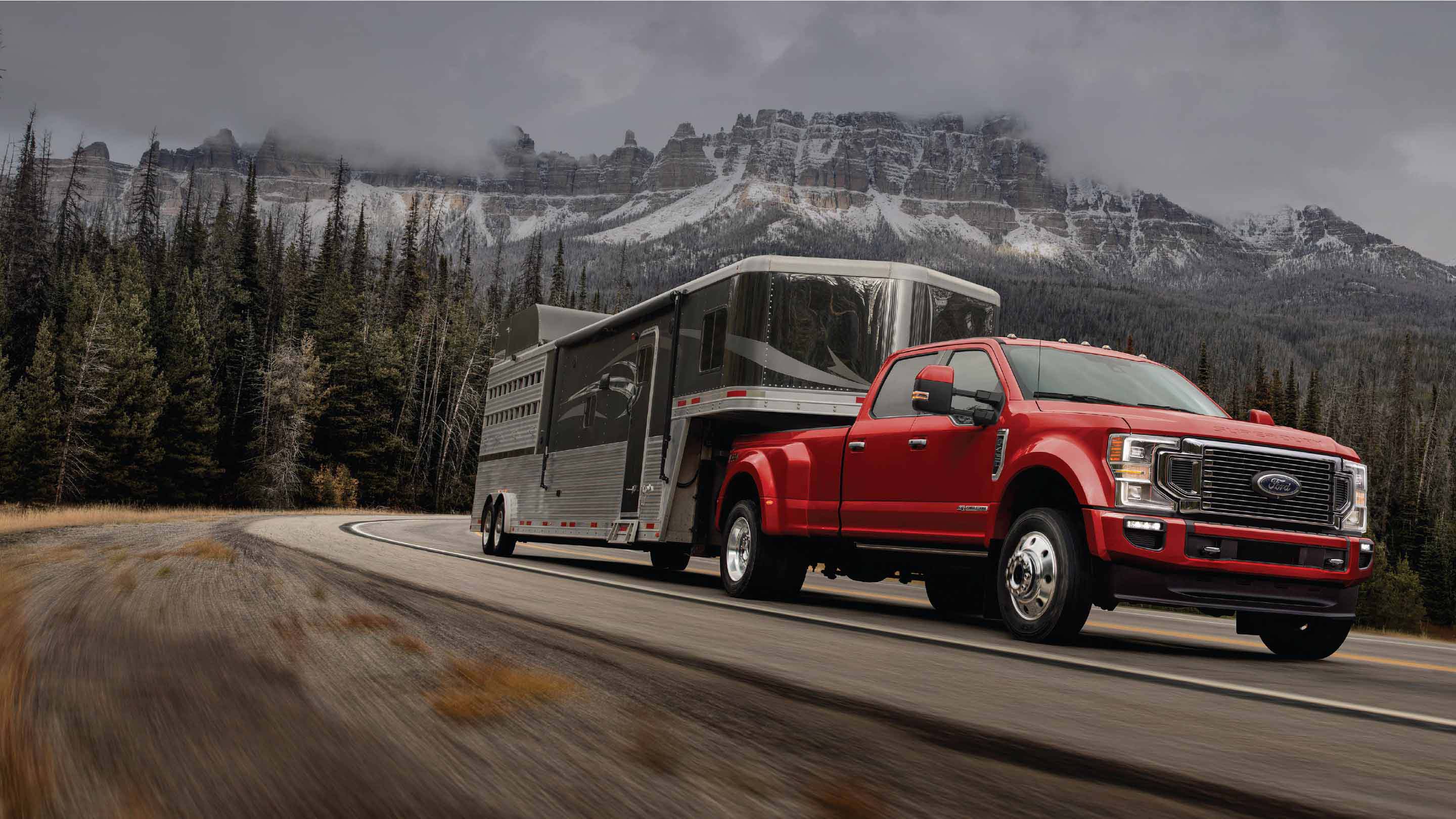 Red Ford pickup truck driving with connected trailer