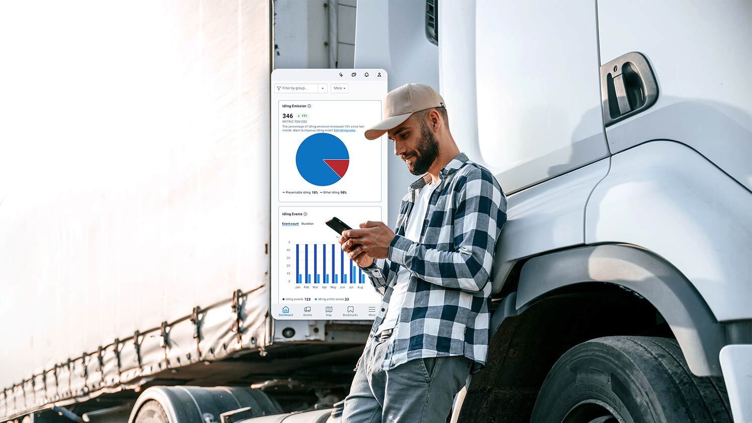 Person standing next to a semi truck using MyGeotab on phone