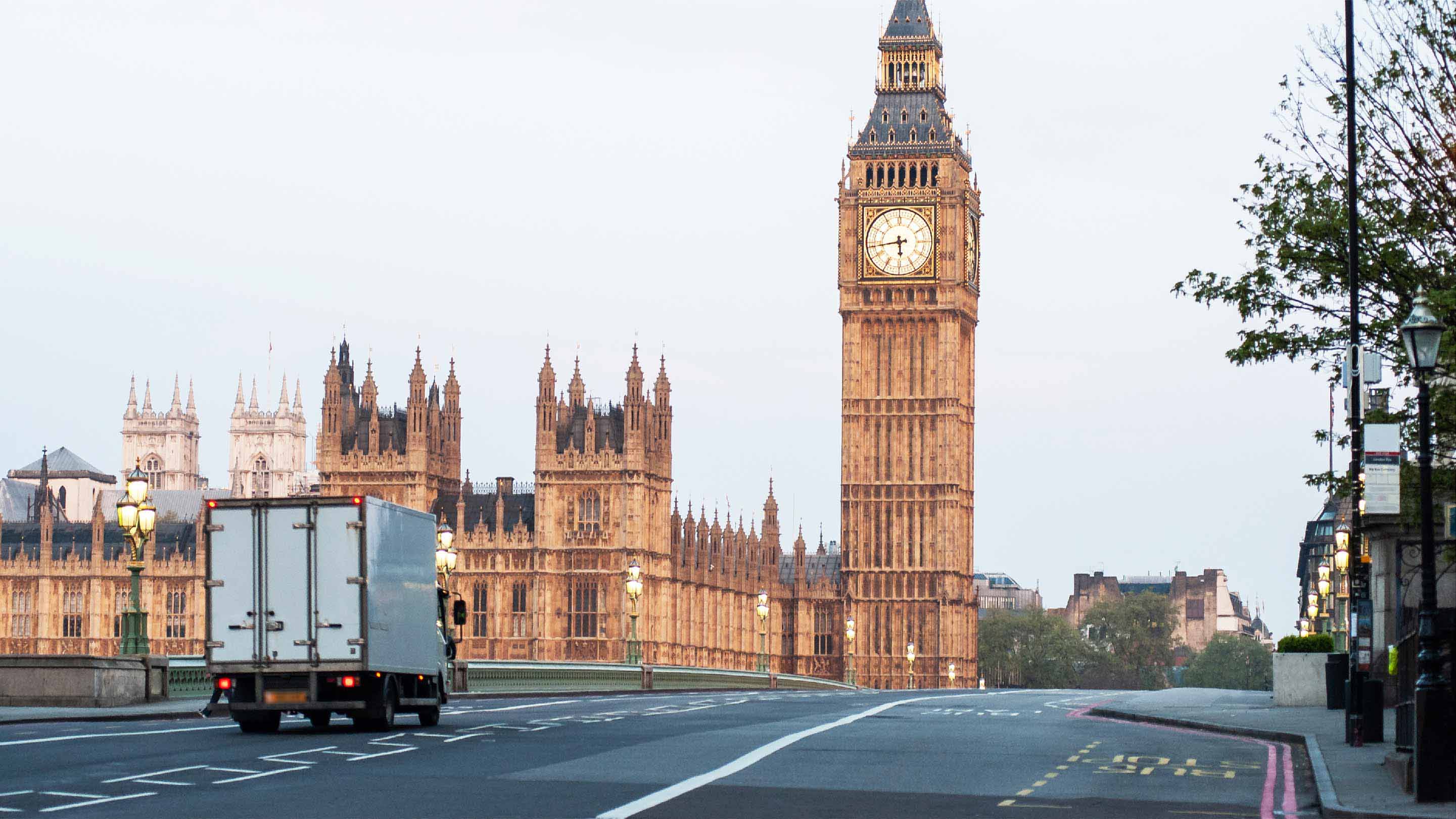 Transport truck driving in front of tall buildings in London, U.K.