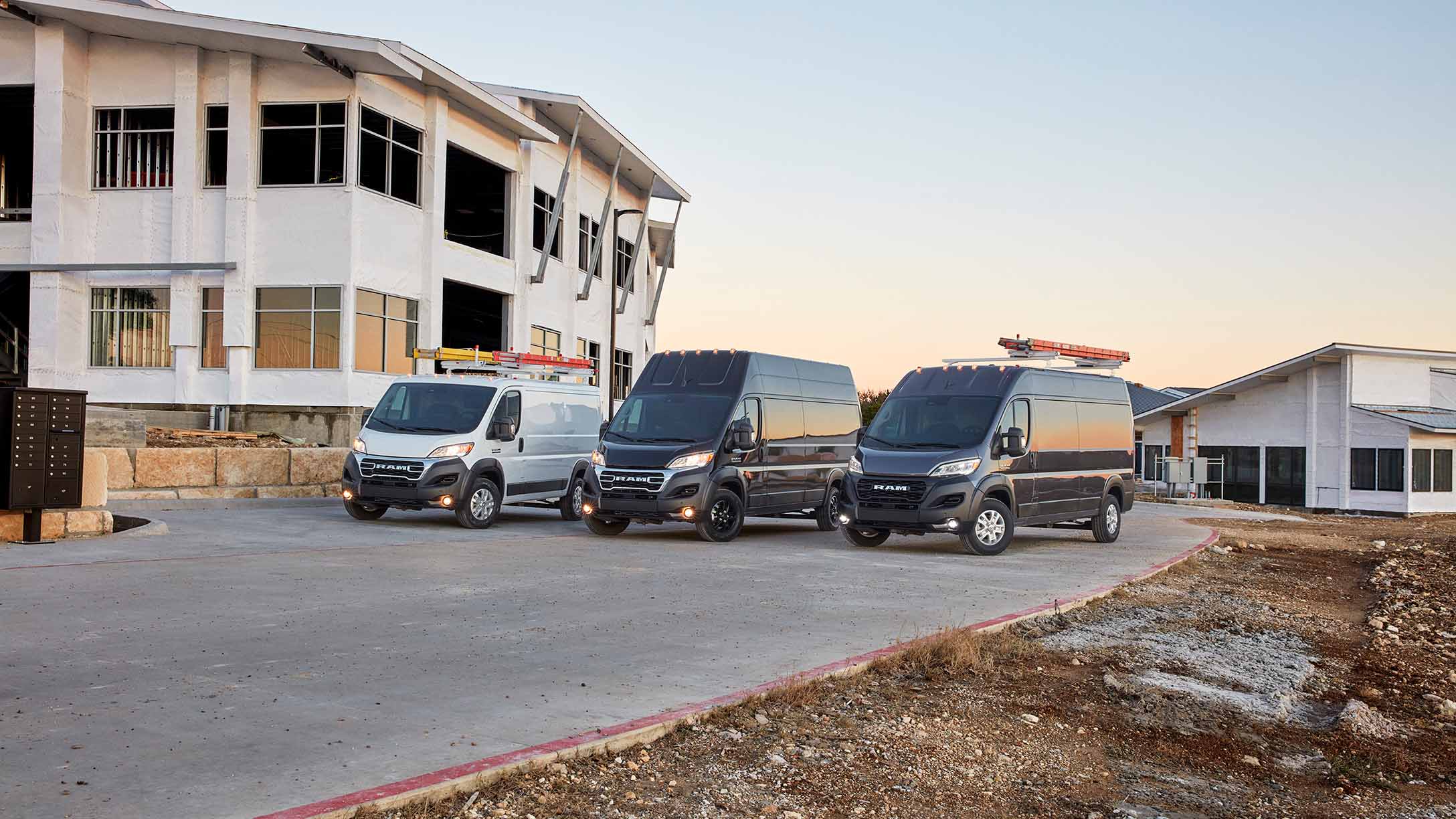 Vans parked in a row by a building