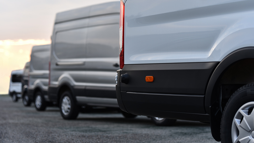 Geotab Greening the Fleet survey title overlaid ontop of a row of white vans