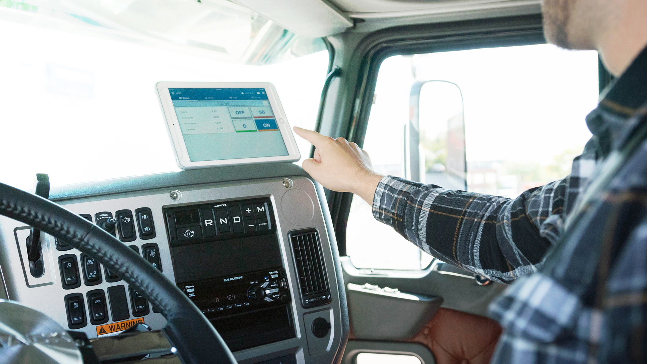 An image of a driver using a tablet fixed to their car dash