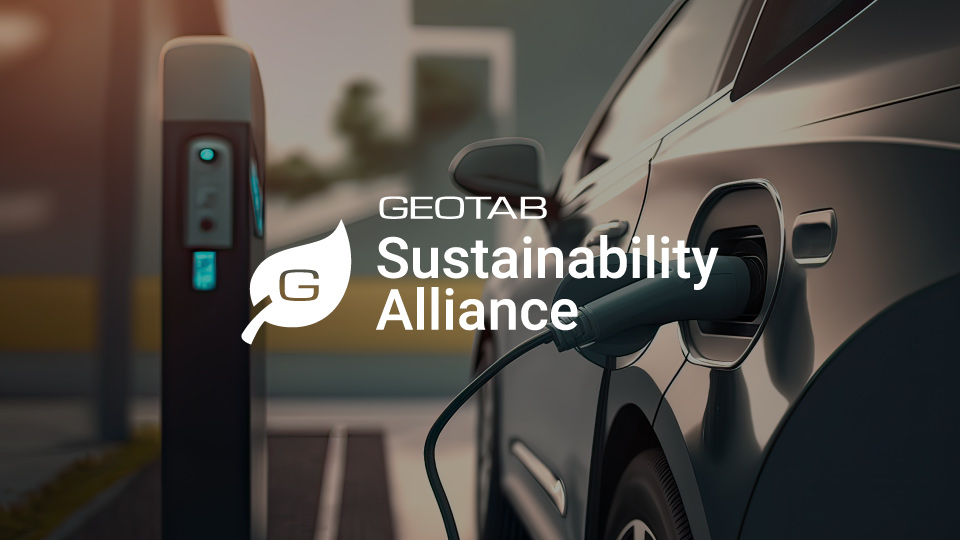 Auto elettrica ferma in ricarica con logo Geotab Sustainability Alliance sopra