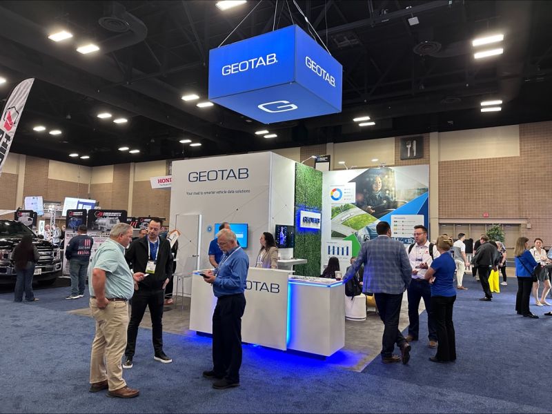 People standing around a Geotab booth at a tradeshow