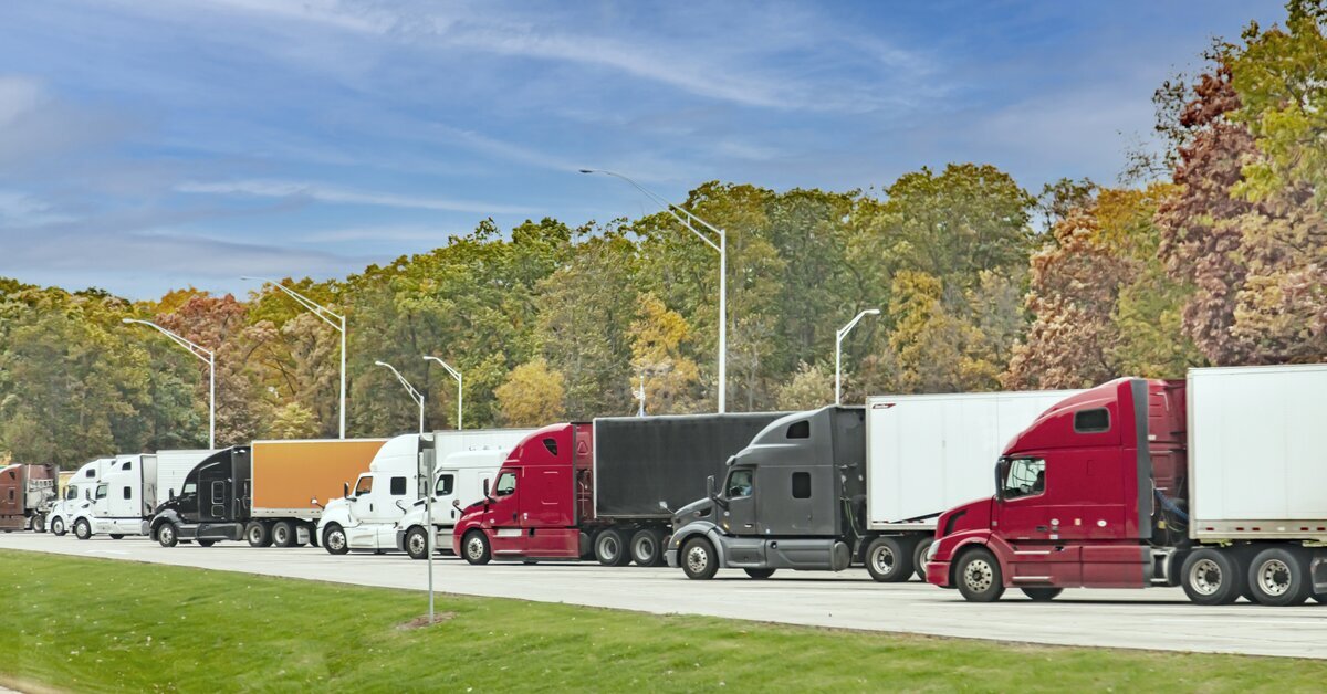 Row of trucks in front of trees