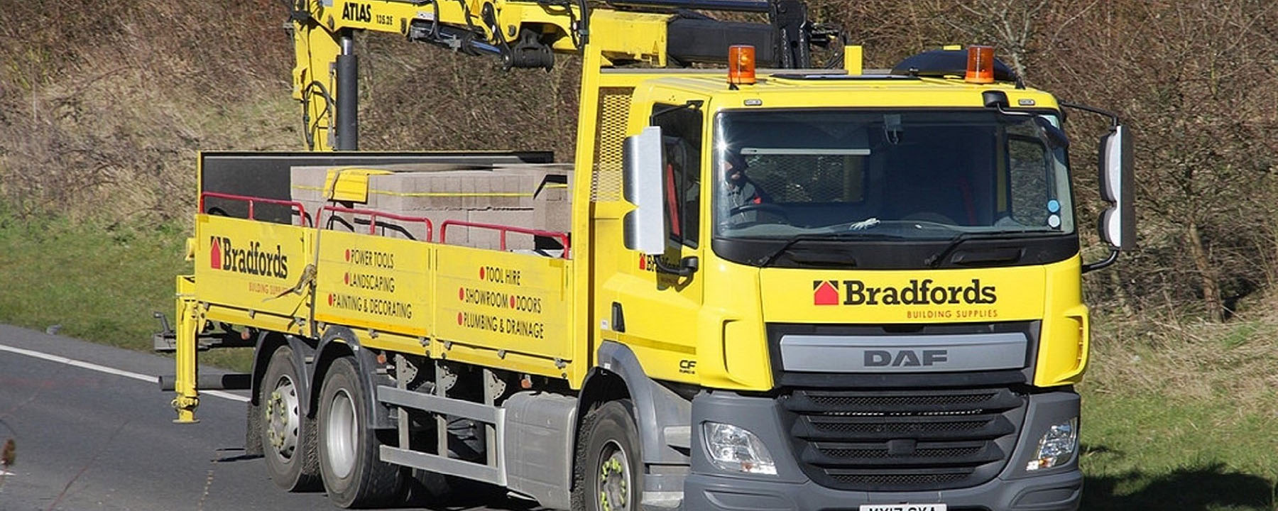 Yellow truck that loads cargo with lumber 