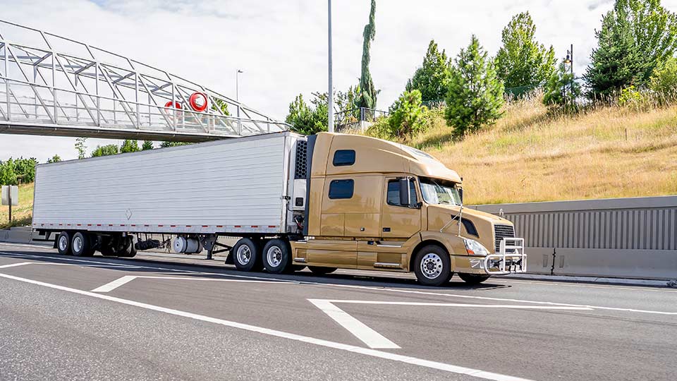 Yellow trailer truck driving on road