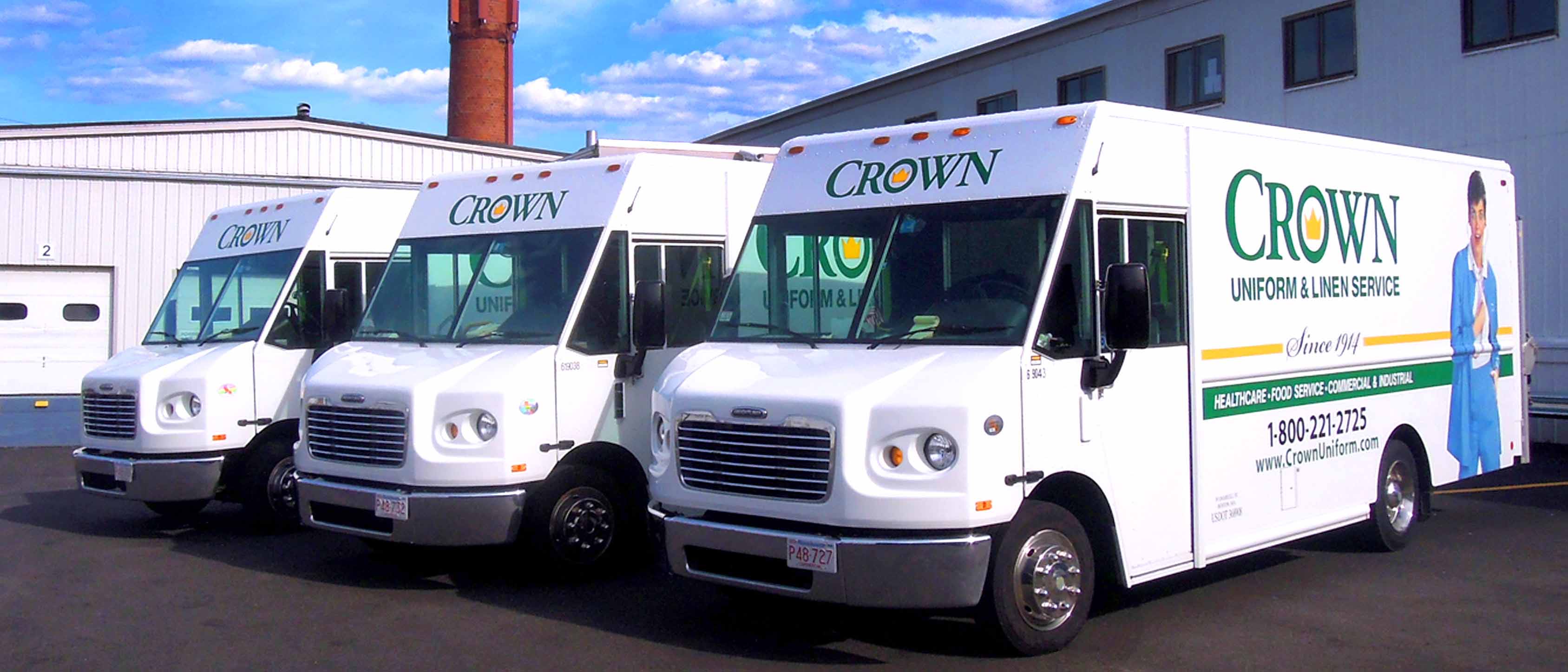 Three parked CROWN Uniform & Linen Service trucks