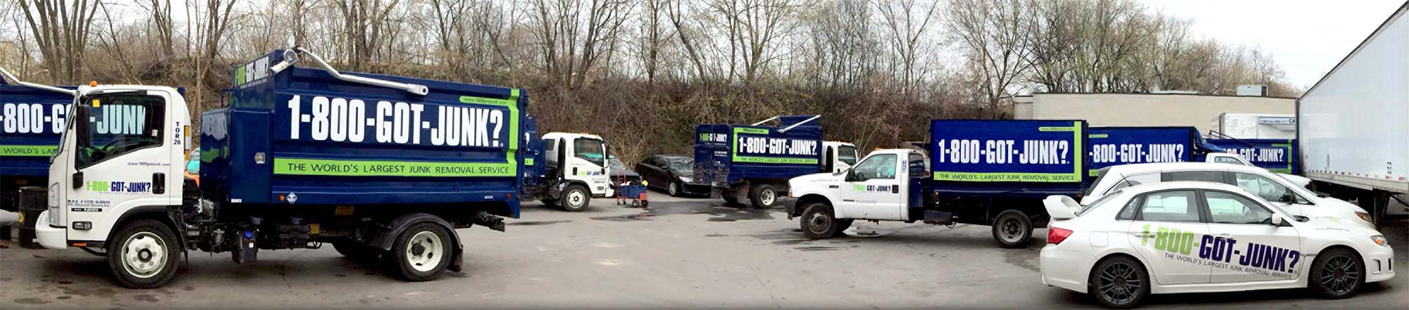 Vehicles parked in a parking lot that have '1-800-Got-Junk' branding on them