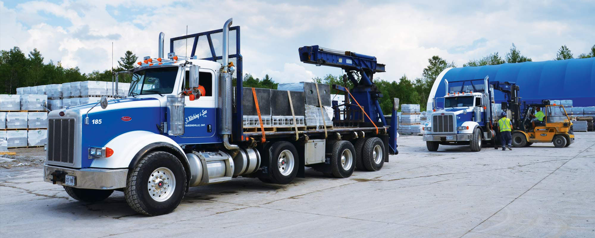 Blue transport truck with J.F. Kitching logo on it